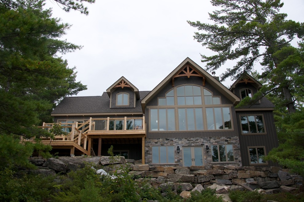 This is an example of a large country three-storey brown exterior in Toronto with stone veneer.