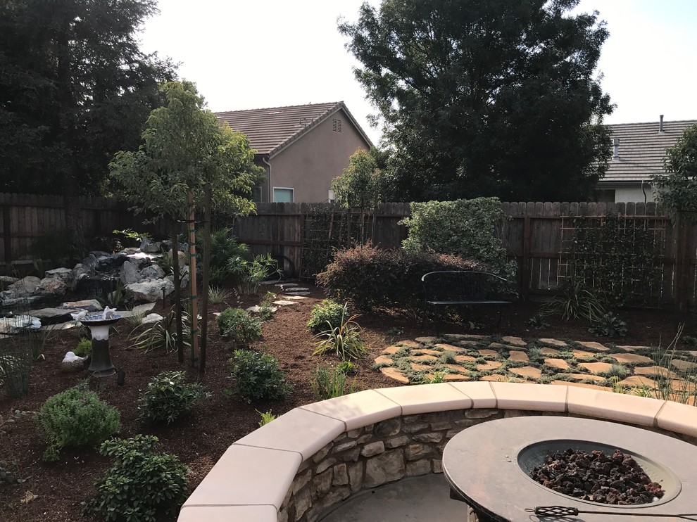 Patio - mid-sized transitional backyard stone patio idea with a fire pit and no cover