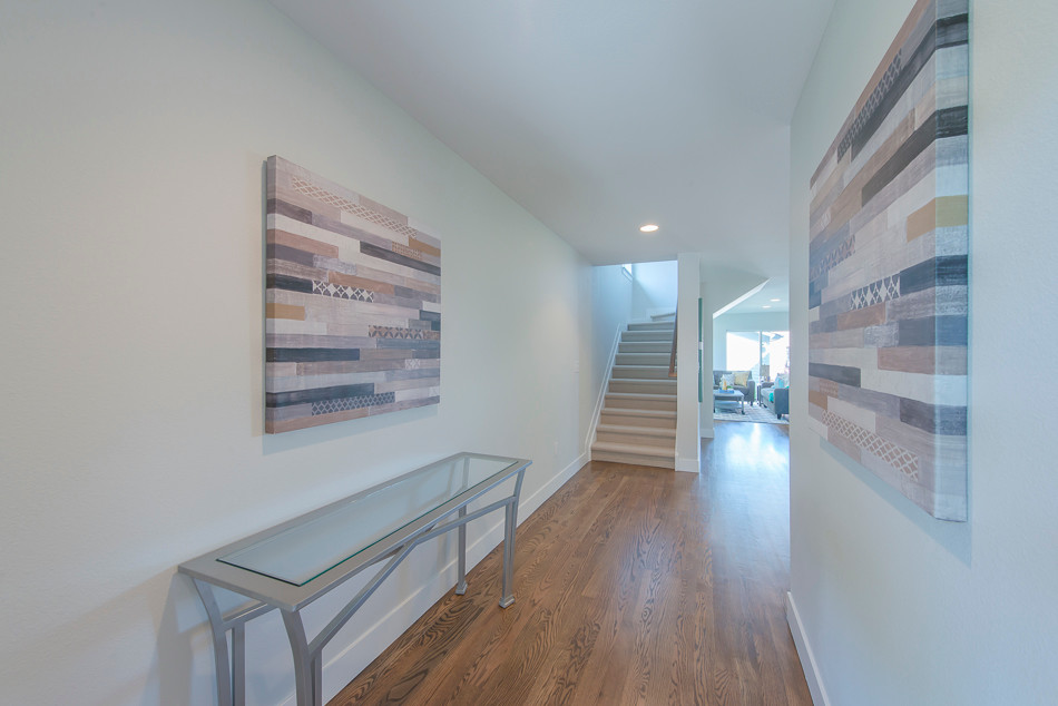 Inspiration for a mid-sized transitional medium tone wood floor hallway remodel in Denver with gray walls