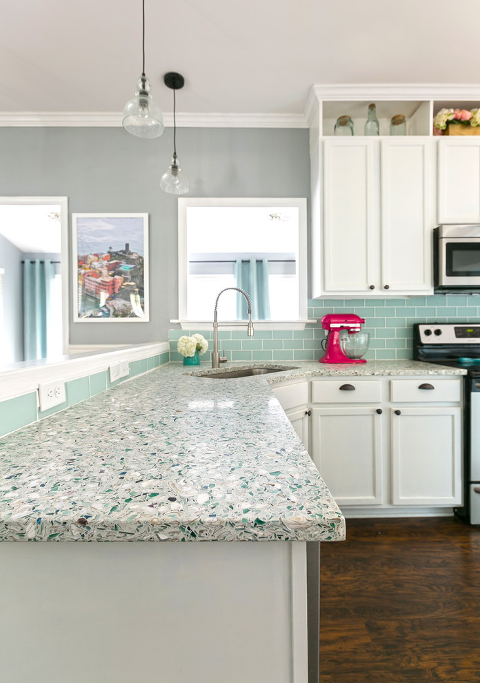 This is an example of a medium sized nautical u-shaped kitchen/diner in Charleston with shaker cabinets, recycled glass countertops, blue splashback, stainless steel appliances, an island, a single-bowl sink, white cabinets, dark hardwood flooring, brown floors and metro tiled splashback.