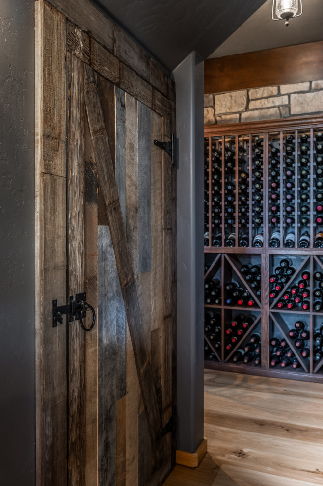 Design ideas for a mid-sized country wine cellar in Portland with medium hardwood floors and diamond bins.