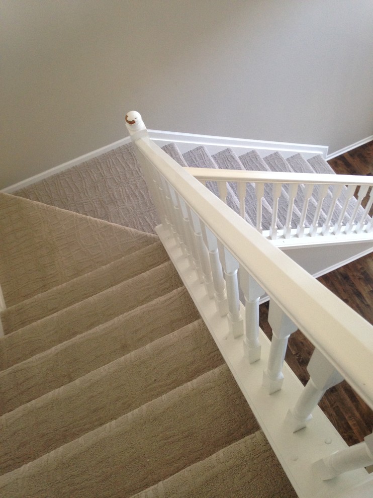 This is an example of a transitional carpeted staircase in Indianapolis with carpet risers.