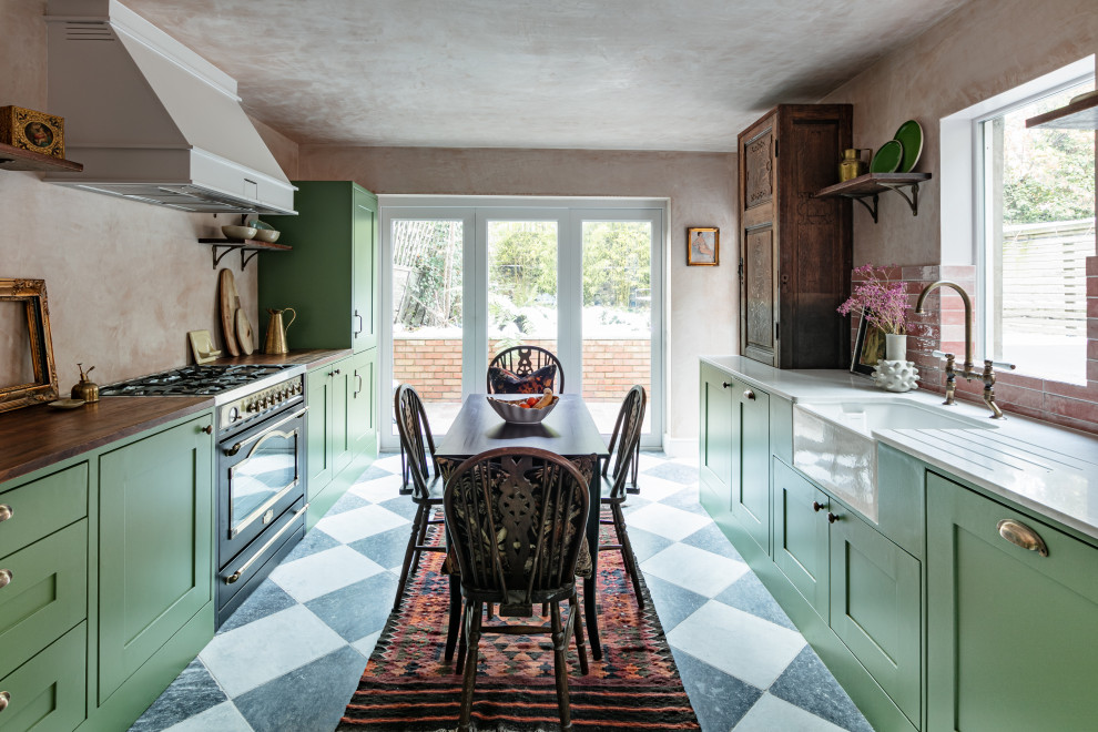 This is an example of a medium sized rustic galley kitchen/diner in London with a belfast sink, shaker cabinets, green cabinets, quartz worktops, pink splashback, ceramic splashback, no island, multi-coloured floors and white worktops.