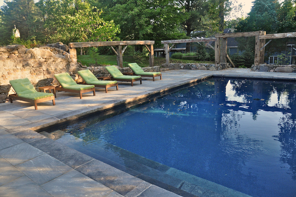 Inspiration for a mid-sized timeless backyard rectangular and stone lap pool remodel