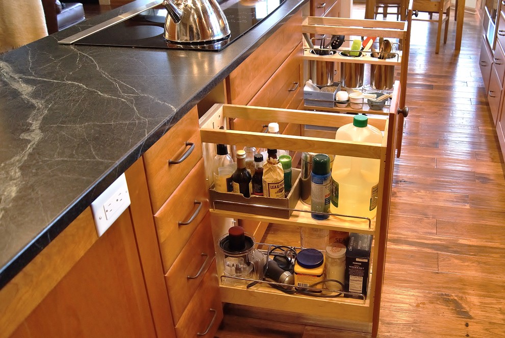 Transitional galley medium tone wood floor eat-in kitchen photo with a double-bowl sink, recessed-panel cabinets, medium tone wood cabinets, soapstone countertops, stainless steel appliances and an island