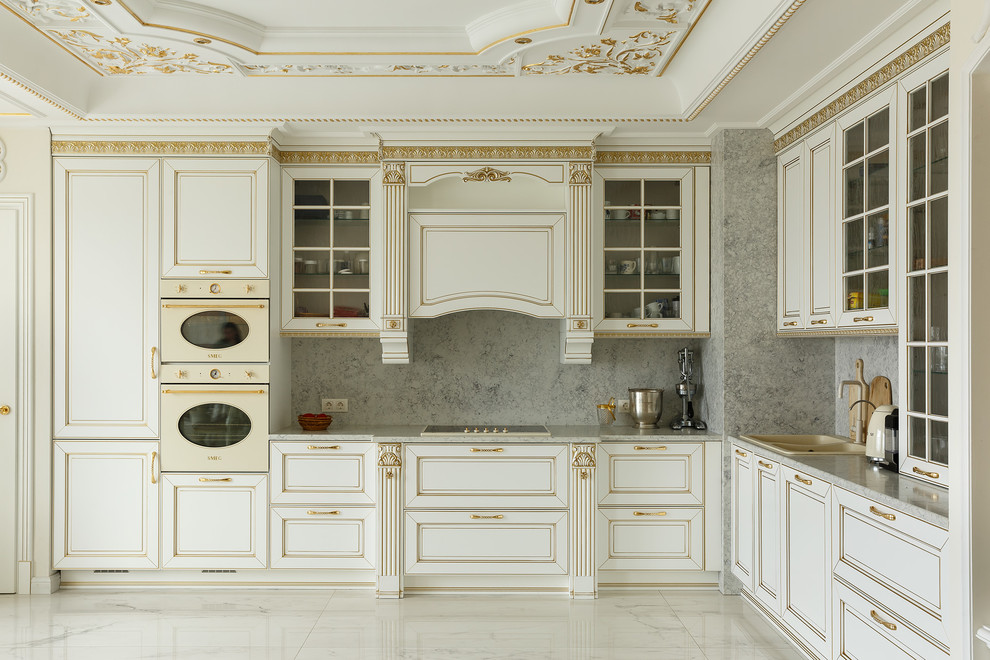 Inspiration for a traditional l-shaped kitchen in Saint Petersburg with a drop-in sink, raised-panel cabinets, beige cabinets, grey splashback, coloured appliances, beige floor and grey benchtop.