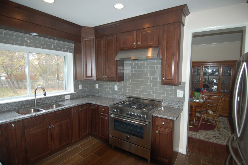 Eat-in kitchen - mid-sized transitional u-shaped plywood floor eat-in kitchen idea in DC Metro with an undermount sink, shaker cabinets, dark wood cabinets, granite countertops, gray backsplash, glass tile backsplash, stainless steel appliances and a peninsula