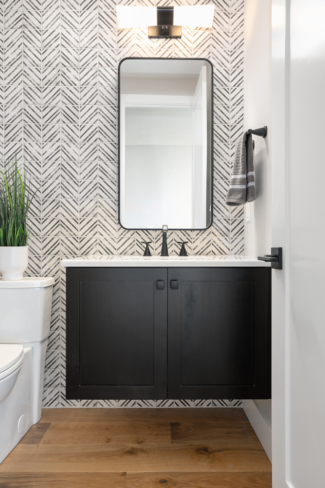 This is an example of a small modern shower room bathroom in Portland with shaker cabinets, black cabinets, a one-piece toilet, black and white tiles, porcelain tiles, white walls, medium hardwood flooring, a built-in sink, engineered stone worktops, brown floors, white worktops, an enclosed toilet, a single sink and a floating vanity unit.