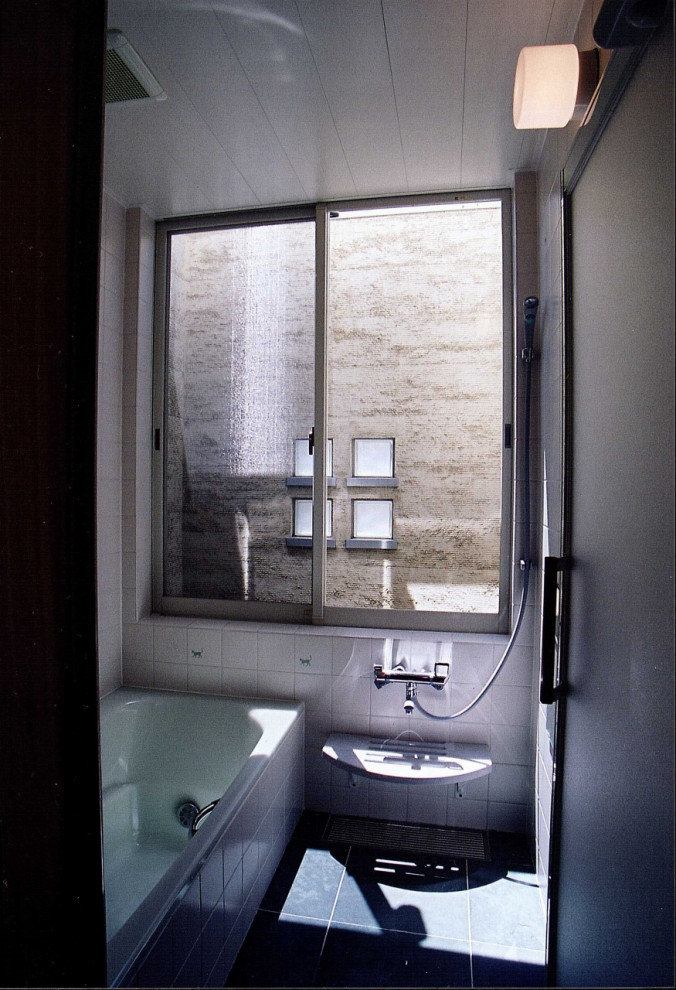 Стильный дизайн: ванная комната в стиле модернизм с гидромассажной ванной, белыми стенами, полом из сланца и черным полом - последний тренд