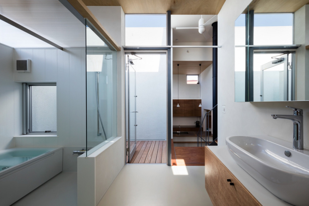 Photo of a medium sized modern grey and brown ensuite wet room bathroom in Other with freestanding cabinets, white cabinets, a built-in bath, a wall mounted toilet, white tiles, white walls, lino flooring, a vessel sink, solid surface worktops, white floors, a hinged door, white worktops, a laundry area, a single sink, a built in vanity unit, a timber clad ceiling and wallpapered walls.