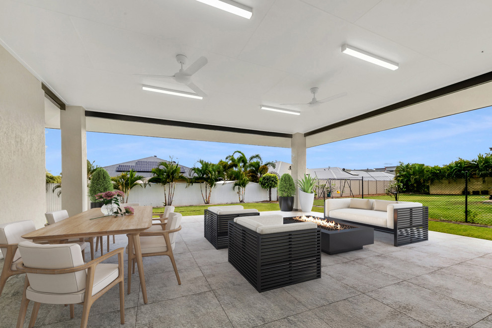 Réalisation d'une grande terrasse arrière minimaliste avec du carrelage et une extension de toiture.