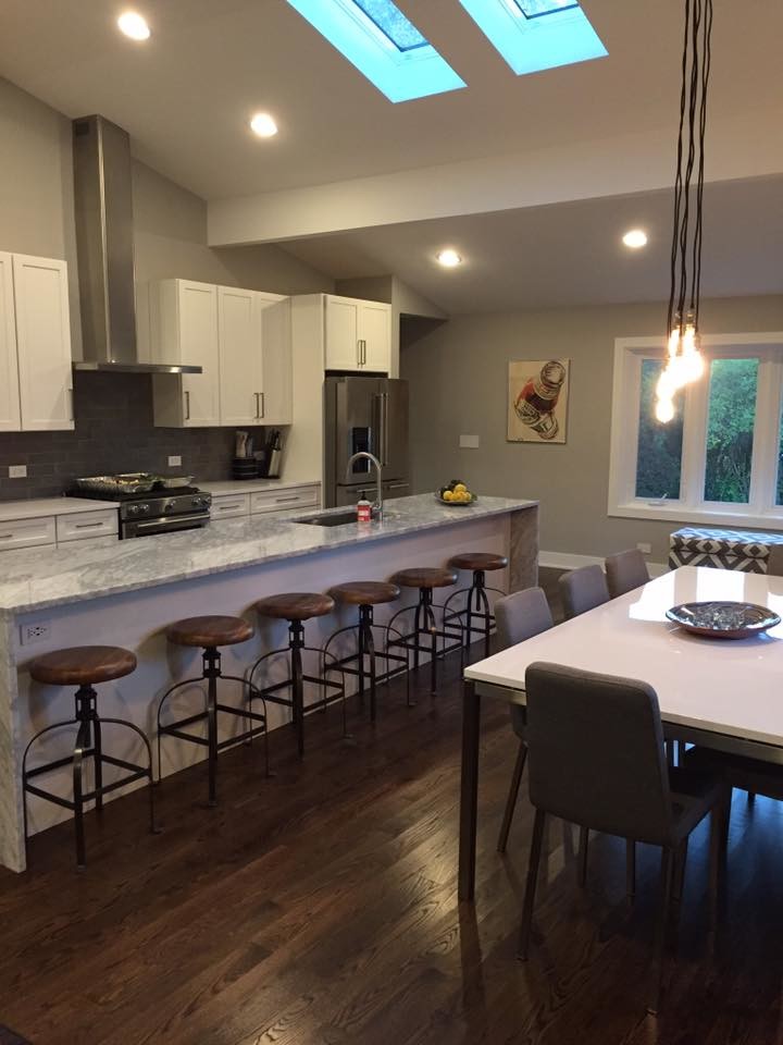 Large transitional u-shaped medium tone wood floor and brown floor open concept kitchen photo in Chicago with an undermount sink, shaker cabinets, white cabinets, quartzite countertops, gray backsplash, subway tile backsplash, stainless steel appliances and an island