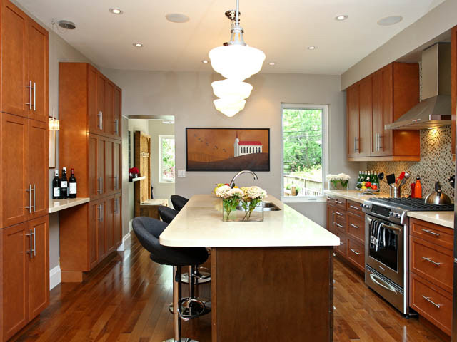 Kitchen - large transitional galley medium tone wood floor and multicolored floor kitchen idea in Toronto with a double-bowl sink, shaker cabinets, medium tone wood cabinets, quartz countertops, multicolored backsplash, glass tile backsplash, stainless steel appliances and an island