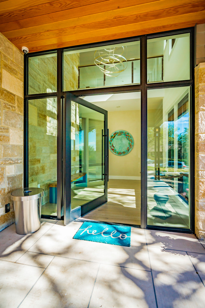 Photo of a large traditional front door in Austin with beige walls, limestone floors, a pivot front door, a metal front door and beige floor.