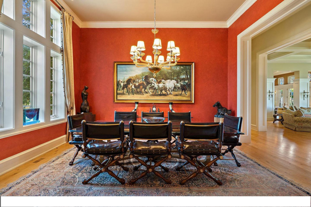 This is an example of a mid-sized separate dining room in DC Metro with red walls and light hardwood floors.