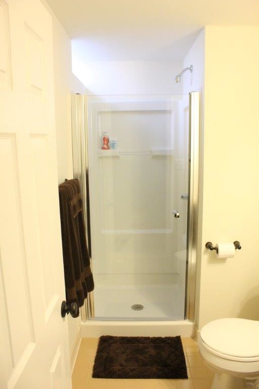 This is an example of a small classic shower room bathroom in Detroit with an alcove shower, a two-piece toilet, beige tiles, ceramic tiles and ceramic flooring.