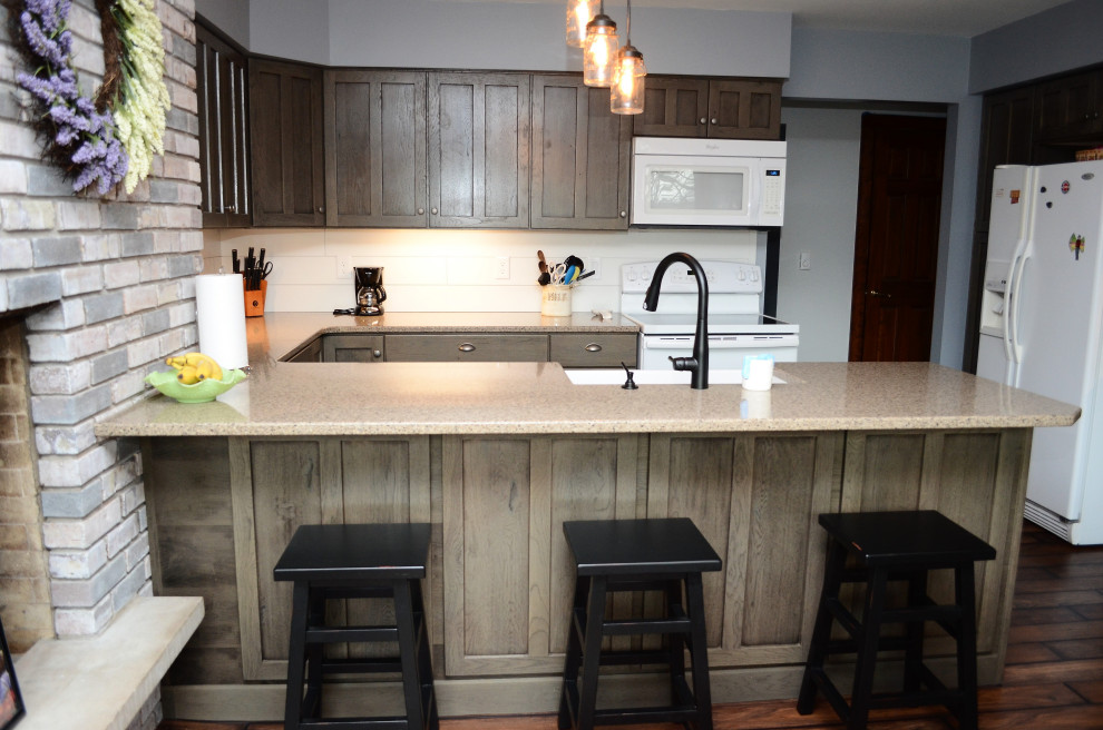 Design ideas for a mid-sized country u-shaped open plan kitchen in Other with a farmhouse sink, recessed-panel cabinets, grey cabinets, quartzite benchtops, white splashback, shiplap splashback, white appliances, laminate floors, a peninsula, brown floor and brown benchtop.