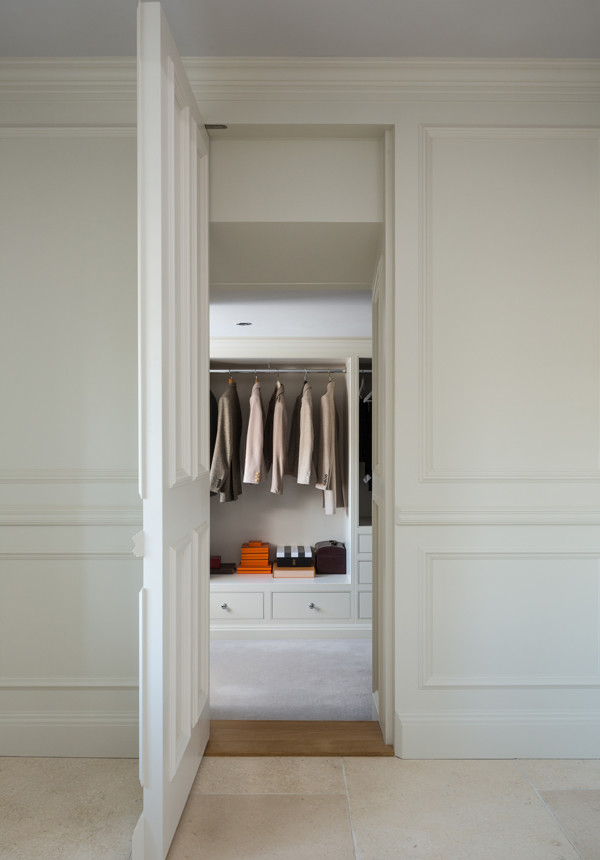 Small traditional gender-neutral dressing room in Other with beaded inset cabinets and carpet.