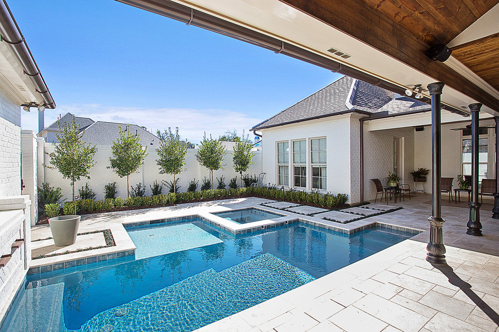 Design ideas for a small contemporary courtyard custom-shaped pool in New Orleans with a hot tub and natural stone pavers.