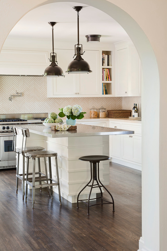 Inspiration for a large mediterranean l-shaped separate kitchen in Los Angeles with shaker cabinets, white cabinets, white splashback, stainless steel appliances, dark hardwood floors, with island, a double-bowl sink and stainless steel benchtops.