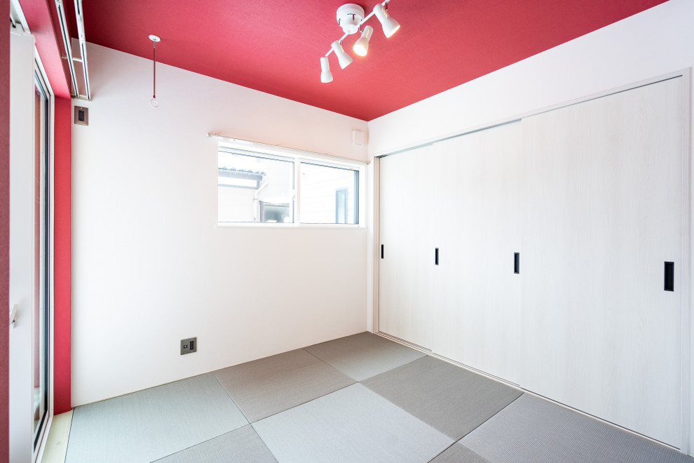Photo of an asian master bedroom in Other with red walls, tatami floors, grey floor and wallpaper.