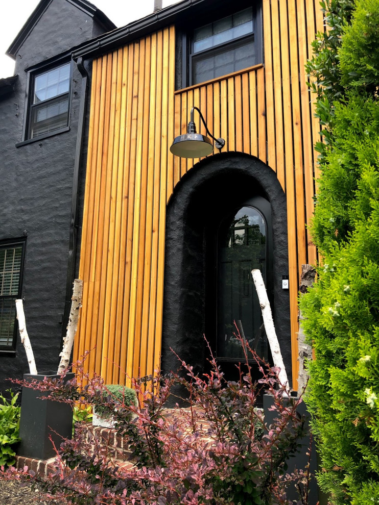Inspiration for a mid-sized contemporary two-storey black house exterior in Other with wood siding.