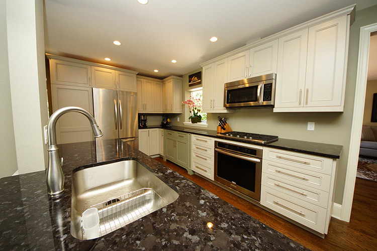 Eat-in kitchen - mid-sized transitional galley marble floor eat-in kitchen idea in Orlando with a double-bowl sink, raised-panel cabinets, white cabinets, granite countertops, green backsplash, stainless steel appliances and an island