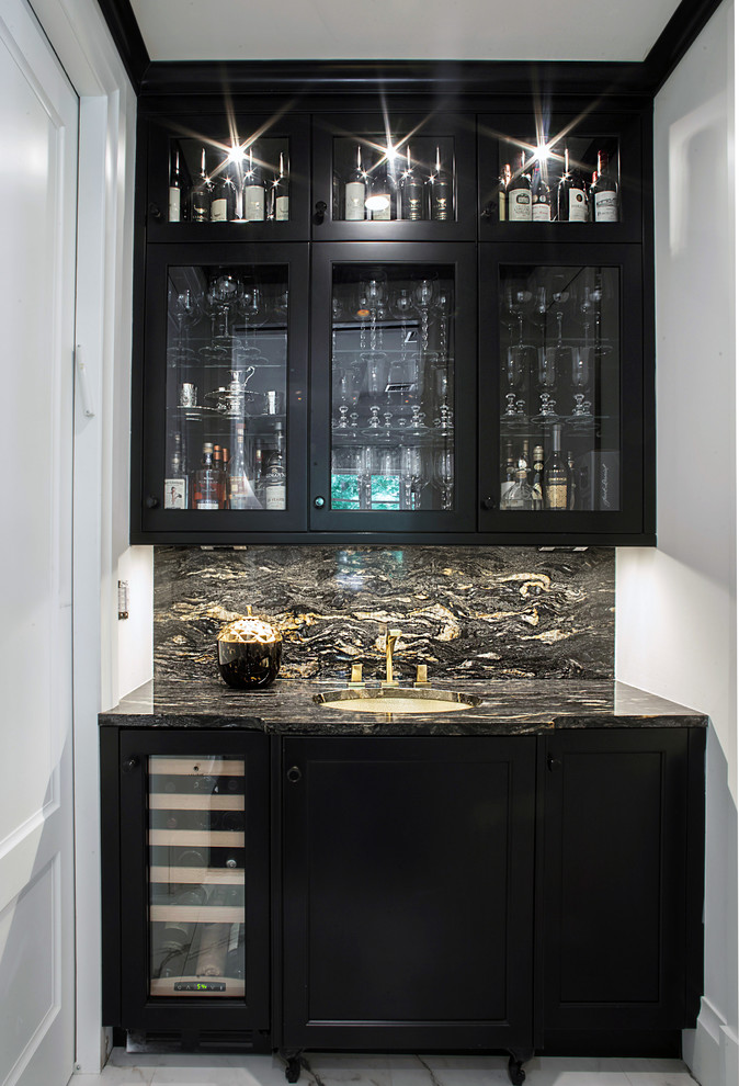 This is an example of a transitional galley home bar in New York with an undermount sink, recessed-panel cabinets, black cabinets, quartzite benchtops, multi-coloured splashback, stone tile splashback and marble floors.