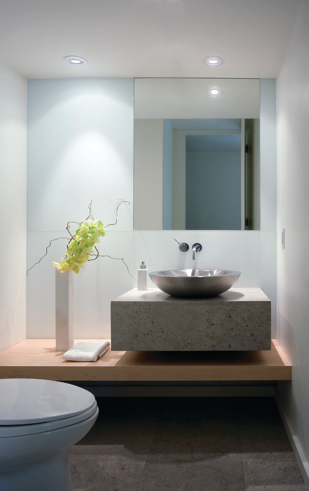 This is an example of a large contemporary powder room in Other with a vessel sink, gray tile, a one-piece toilet, white walls, limestone floors and limestone benchtops.