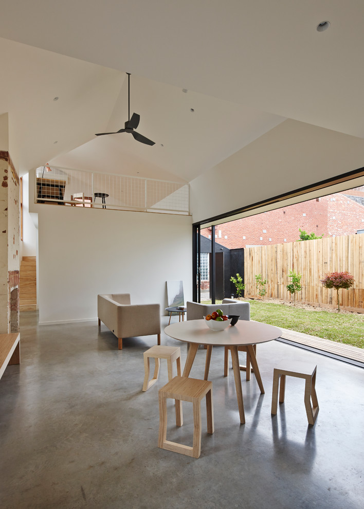 This is an example of a mid-sized contemporary dining room in Melbourne with white walls and concrete floors.