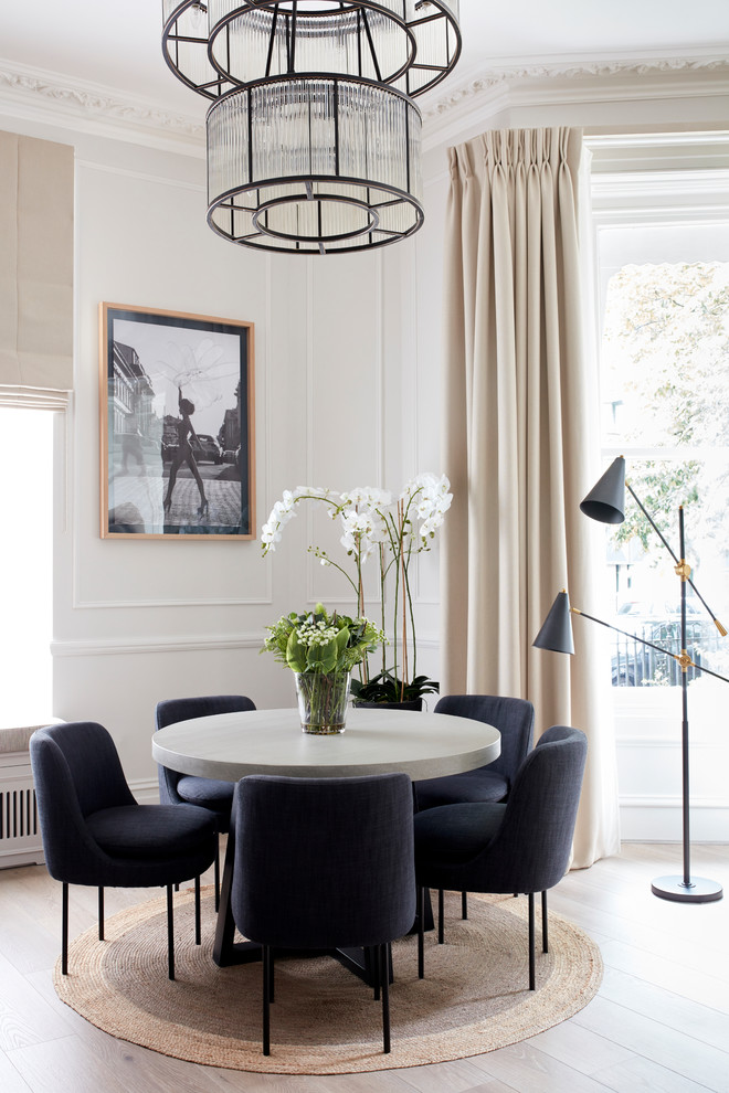 Inspiration for a mid-sized transitional open plan dining in London with beige walls, laminate floors and beige floor.