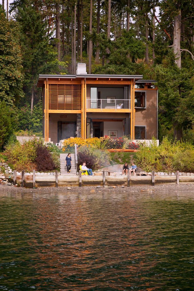 Inspiration for a beach style two-storey exterior in Seattle with mixed siding and a flat roof.