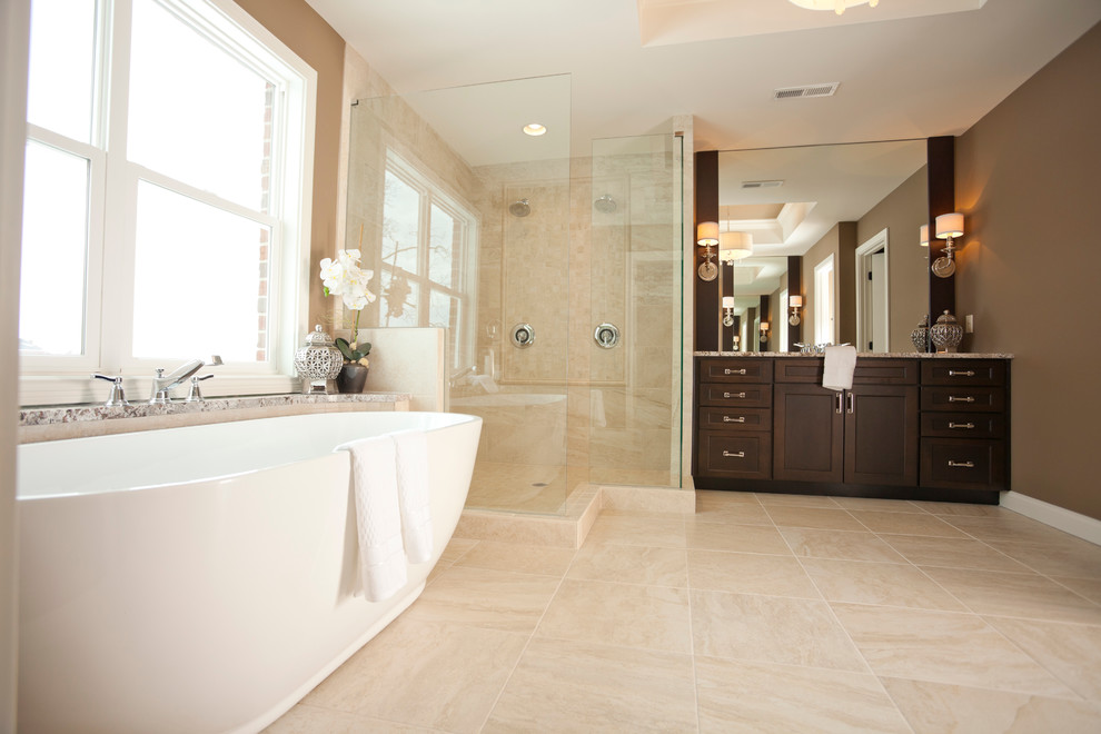 Photo of a mid-sized transitional bathroom in Cincinnati with shaker cabinets, dark wood cabinets, a freestanding tub, a corner shower, beige tile and brown walls.