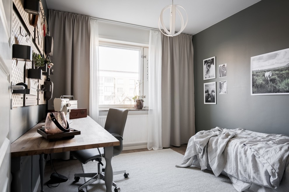 Design ideas for a scandinavian grey and brown bedroom in Gothenburg with grey walls, medium hardwood flooring and brown floors.