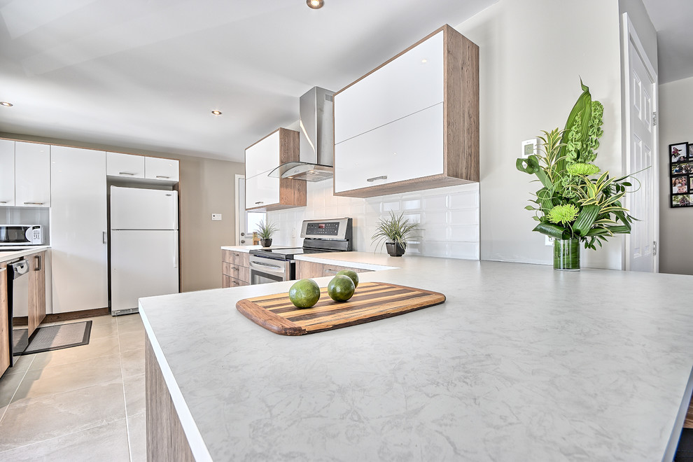 Inspiration for a small contemporary l-shaped eat-in kitchen in Montreal with an undermount sink, flat-panel cabinets, light wood cabinets, laminate benchtops, white splashback, subway tile splashback, white appliances, ceramic floors and a peninsula.