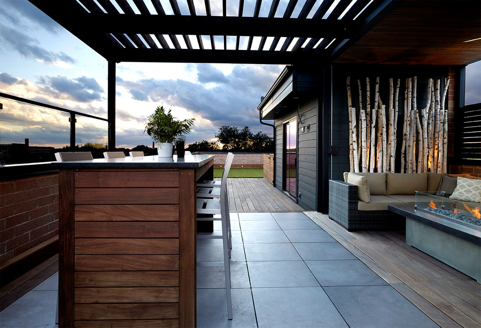 Photo of a large contemporary rooftop deck in Chicago with a fire feature and a roof extension.