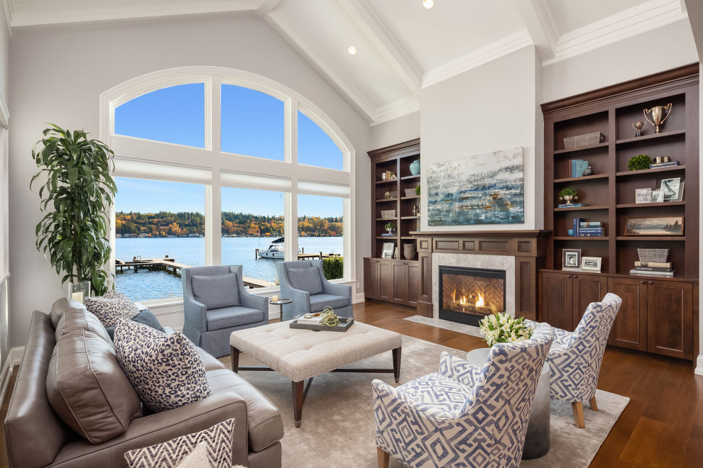 Inspiration for a large beach style open concept living room in Seattle with grey walls, medium hardwood floors, a stone fireplace surround, a concealed tv and brown floor.