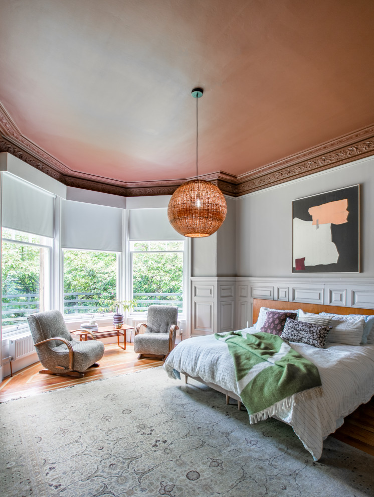 Photo of a large eclectic master bedroom in Glasgow with medium hardwood floors and brown floor.