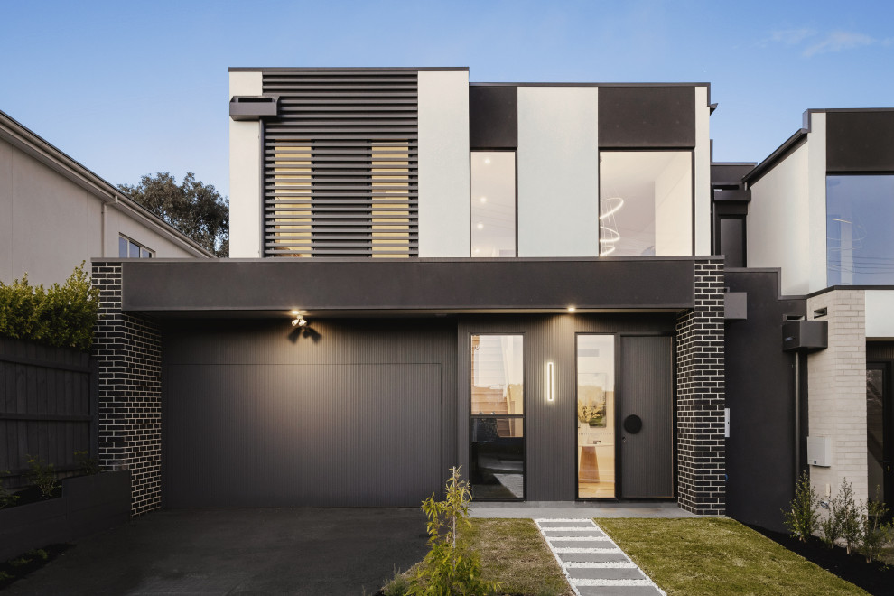 Large contemporary two-storey brick black duplex exterior in Melbourne with a flat roof, a metal roof and a black roof.