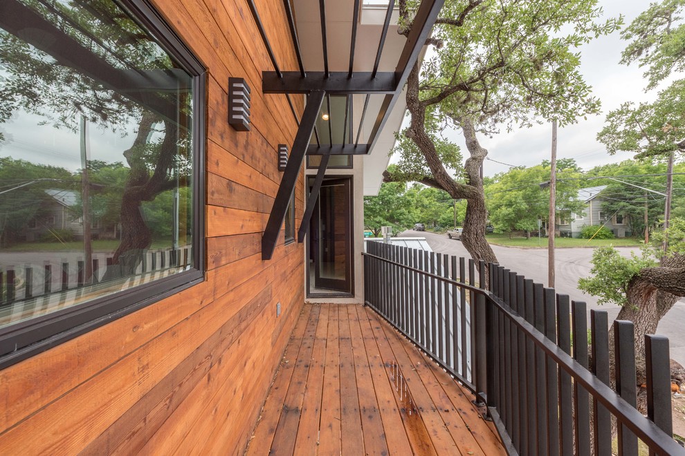 Design ideas for a mid-sized midcentury balcony in Austin with an awning.