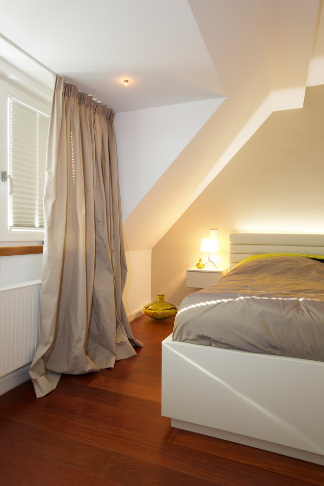 Kleines Modernes Schlafzimmer mit beiger Wandfarbe, braunem Holzboden und beigem Boden in Düsseldorf