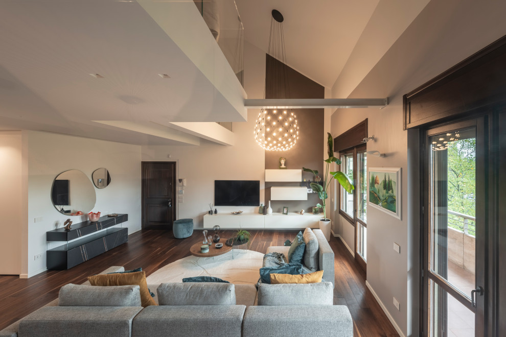 Large modern open concept living room in Milan with white walls, dark hardwood floors, a built-in media wall, brown floor, recessed and wallpaper.