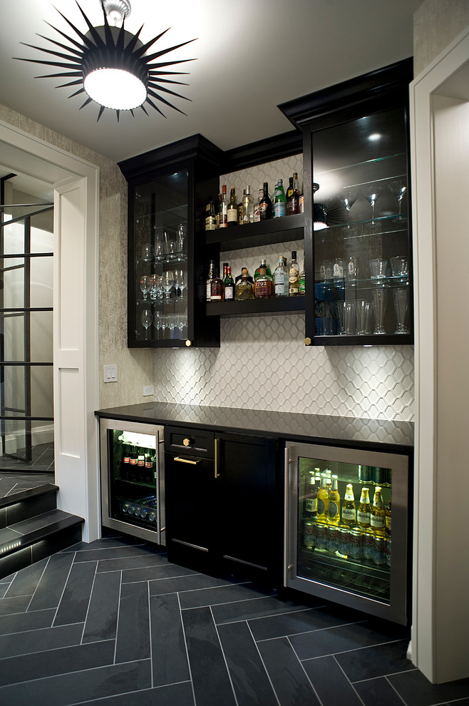 Inspiration for a transitional single-wall home bar in Other with glass-front cabinets, black cabinets, white splashback, no sink, black floor and black benchtop.
