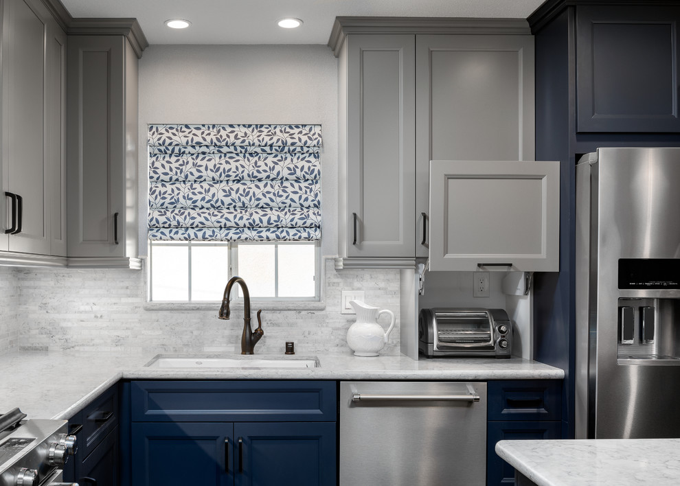 Design ideas for a mid-sized country l-shaped eat-in kitchen in Orange County with an undermount sink, shaker cabinets, blue cabinets, quartz benchtops, grey splashback, limestone splashback, stainless steel appliances, vinyl floors, with island, brown floor and grey benchtop.