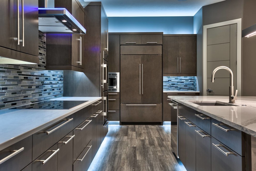 Photo of a mid-sized modern l-shaped open plan kitchen in Omaha with with island, an undermount sink, flat-panel cabinets, brown cabinets, marble benchtops, matchstick tile splashback, stainless steel appliances and dark hardwood floors.