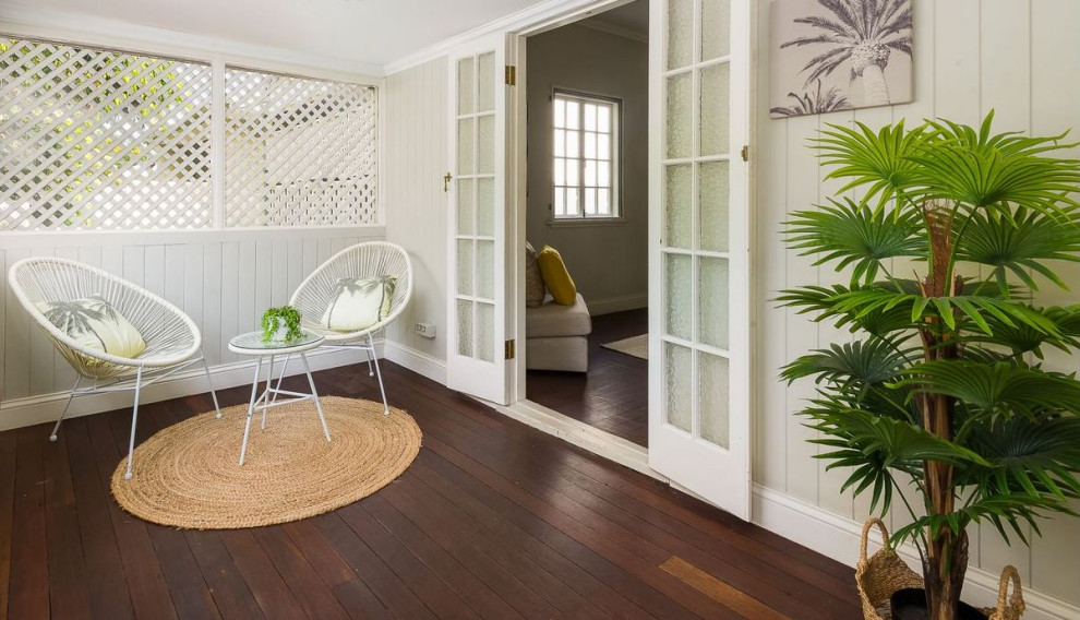 Small tropical front yard screened-in verandah in Brisbane with a roof extension.