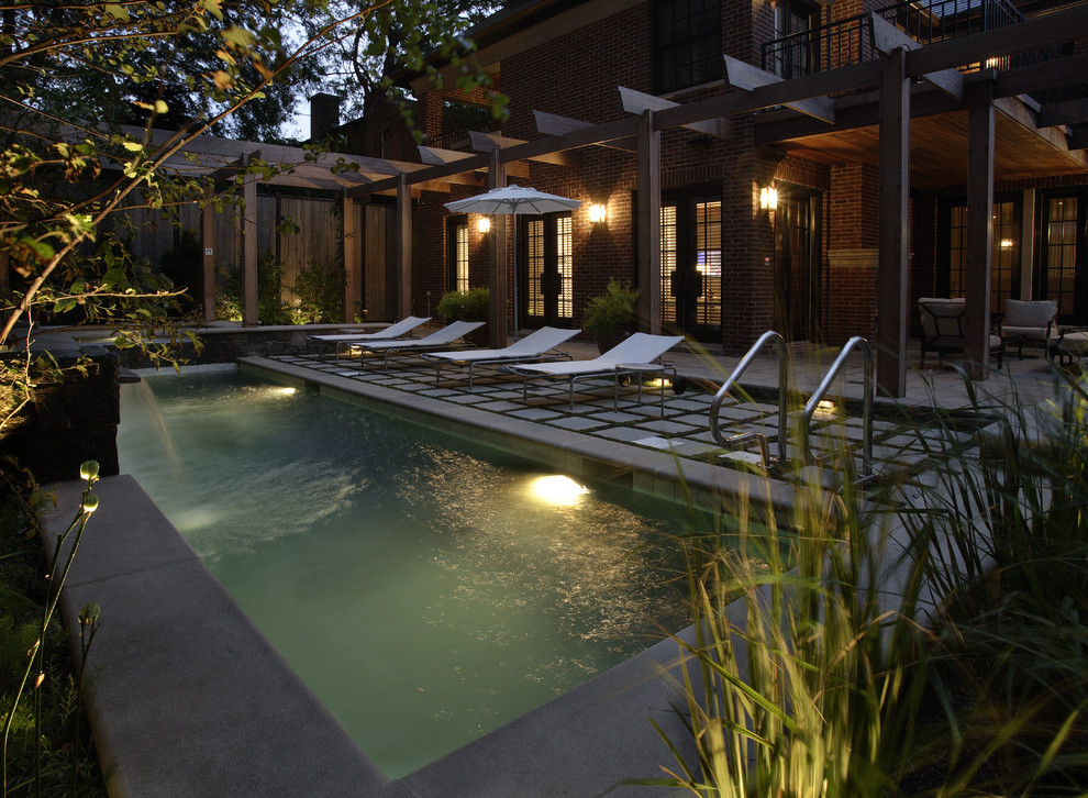 This is an example of a small modern courtyard rectangular lap pool in Chicago with natural stone pavers and a hot tub.