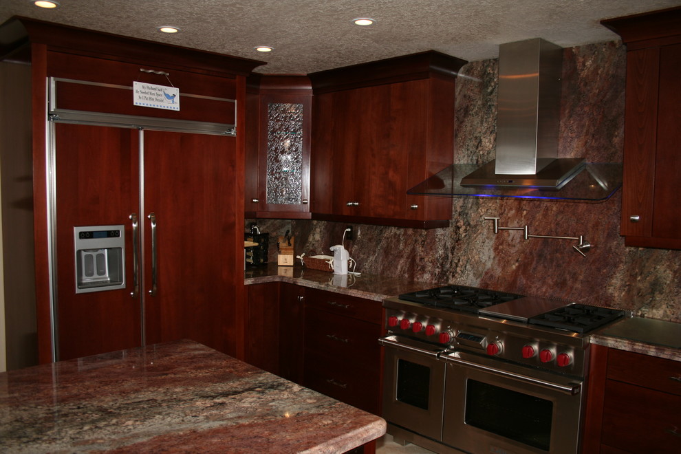 Inspiration for a large transitional u-shaped kitchen remodel in Orange County with raised-panel cabinets, dark wood cabinets and stainless steel appliances