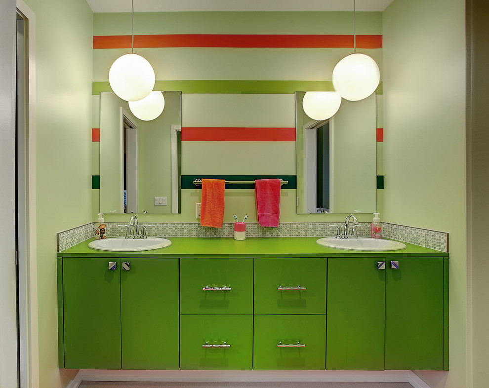 Design ideas for a contemporary kids bathroom in Grand Rapids with a pedestal sink, flat-panel cabinets, green cabinets, granite benchtops, a corner tub, an open shower, gray tile, grey walls and ceramic floors.