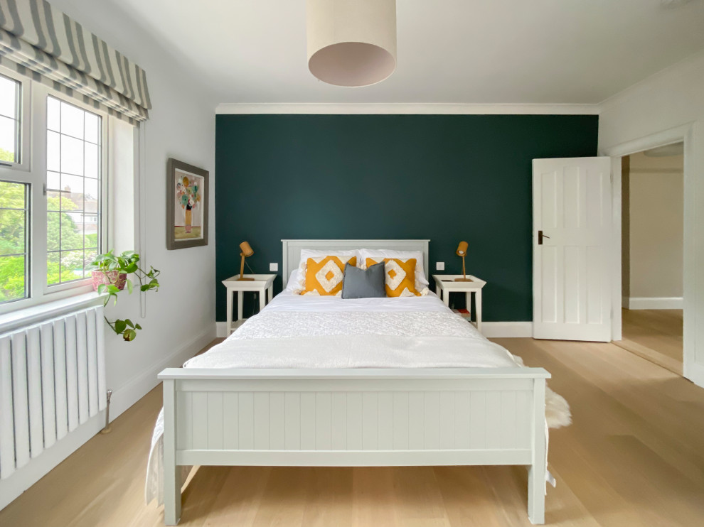 This is an example of a large scandi guest bedroom in Other with white walls, light hardwood flooring and tongue and groove walls.